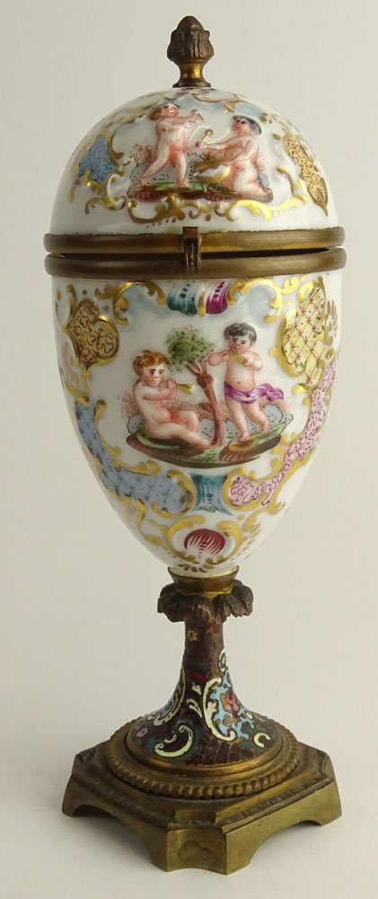 Antique Capodimonte Porcelain Hinged Egg on Bronze and: Antique Capodimonte Porcelain Hinged Egg on Bronze and CloisonnÃ© Base. Hand Decorated Putti Motif. Signed with Crown over N Mark. Good Condition. Measures 8-1/4 Inches Tall. Shipping $55.00