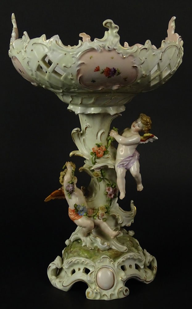 Antique Bavarian Porcelain Figural Compote. The Base: Antique Bavarian Porcelain Figural Compote. The Base with 2 Cherubs amidst Flowers. Reticulated Bowl. Signed with Green Backstamp (B in a Crown). Restoration to Wings. We will not ship this item due t