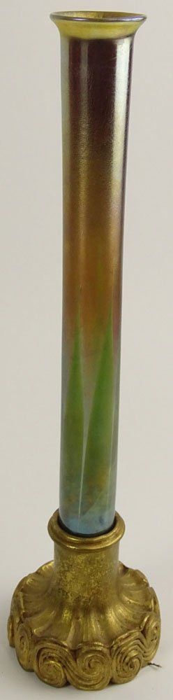Antique Tiffany Favrile Pulled Feather Iridescent Glass: Antique Tiffany Favrile Pulled Feather Iridescent Glass Vase resting in Tiffany Gilt Bronze Base with Scroll Motif. Glass Signed LCT. Base Signed Tiffany Studios 711. Base of Glass With Chip or in Goo