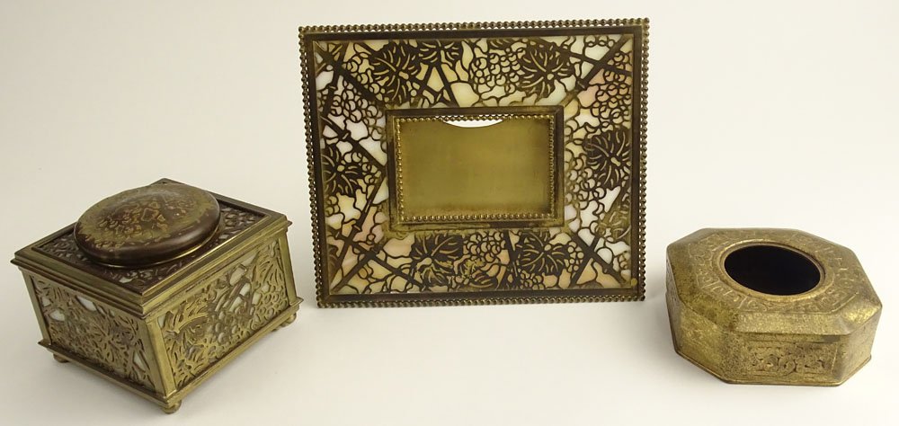 Lot of Three (3) Tiffany Studios Bronze Desk Set: Lot of Three (3) Tiffany Studios Bronze Desk Set Pieces. The Lot includes an Inkwell and Picture Frame in the Grape Vine Motif as well as a smaller Inkwell with No liner or cover in the Greek Key Moti