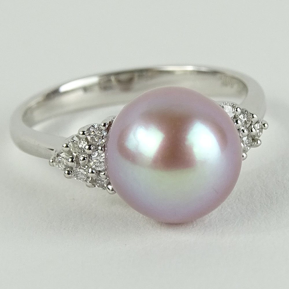 Lady's Pink Pearl and 18 Karat White Gold Ring accented: Lady's Pink Pearl and 18 Karat White Gold Ring accented with small round cut diamond. Pearl measures 9mm. Signed 18K 750. Very good condition. Ring size 6. Approx. weight: 2.50 pennyweights. Shipping
