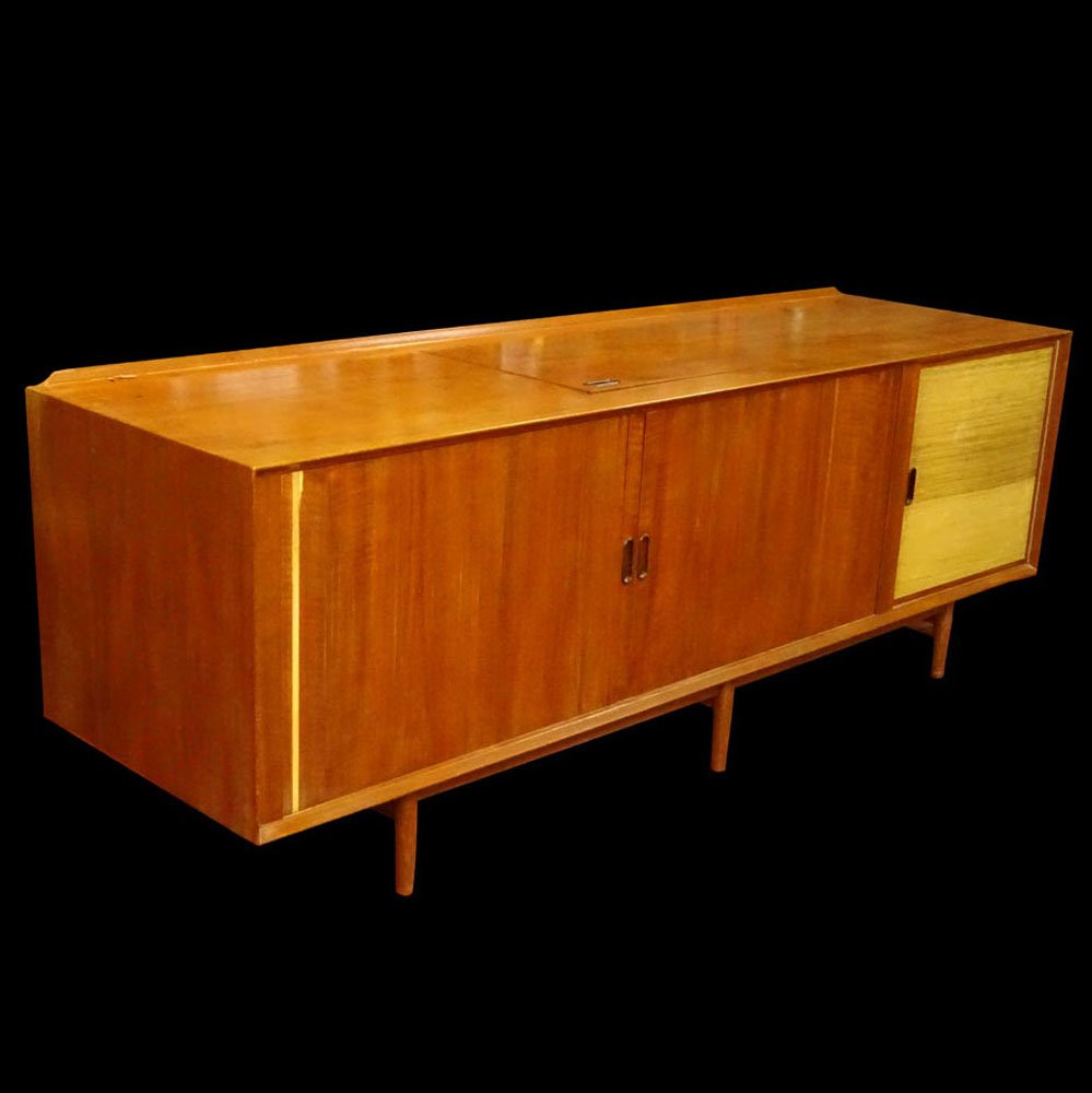 Arne Vodder, Danish (1926-2009) Circa 1960's Teakwood: Arne Vodder, Danish (1926-2009) Circa 1960's Teakwood and Raffia Credenza. Unsigned. Rubbing, surface wear, strip of veneer missing, hole cut to back. Measures 30" H, 84" L, 24" D. Domestic Shipping T