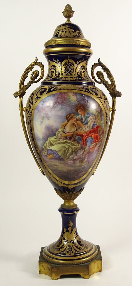 Large 19/20th Century Hand Painted Bronze Mounted: Large 19/20th Century Hand Painted Bronze Mounted Sevres Urn with Lid. The Front Panel Depicting a Hand Painted Romantic Scene Signed Bombois. Ornate Gilt Decoration Throughout on Cobalt Ground. Wreat