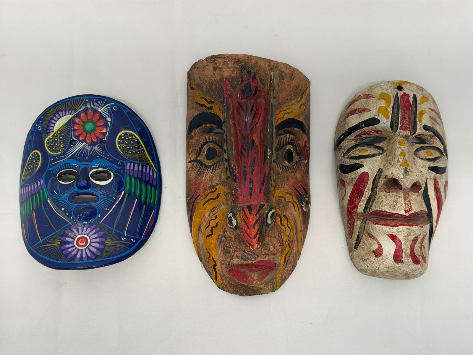 (3)Mexican Masks - (2)Are Carved Wood, (1) is Pottery: Asst Carved & Handpainted , Clay Mask 8" x 6.5" , Carved with Bird 10.75" x 6"