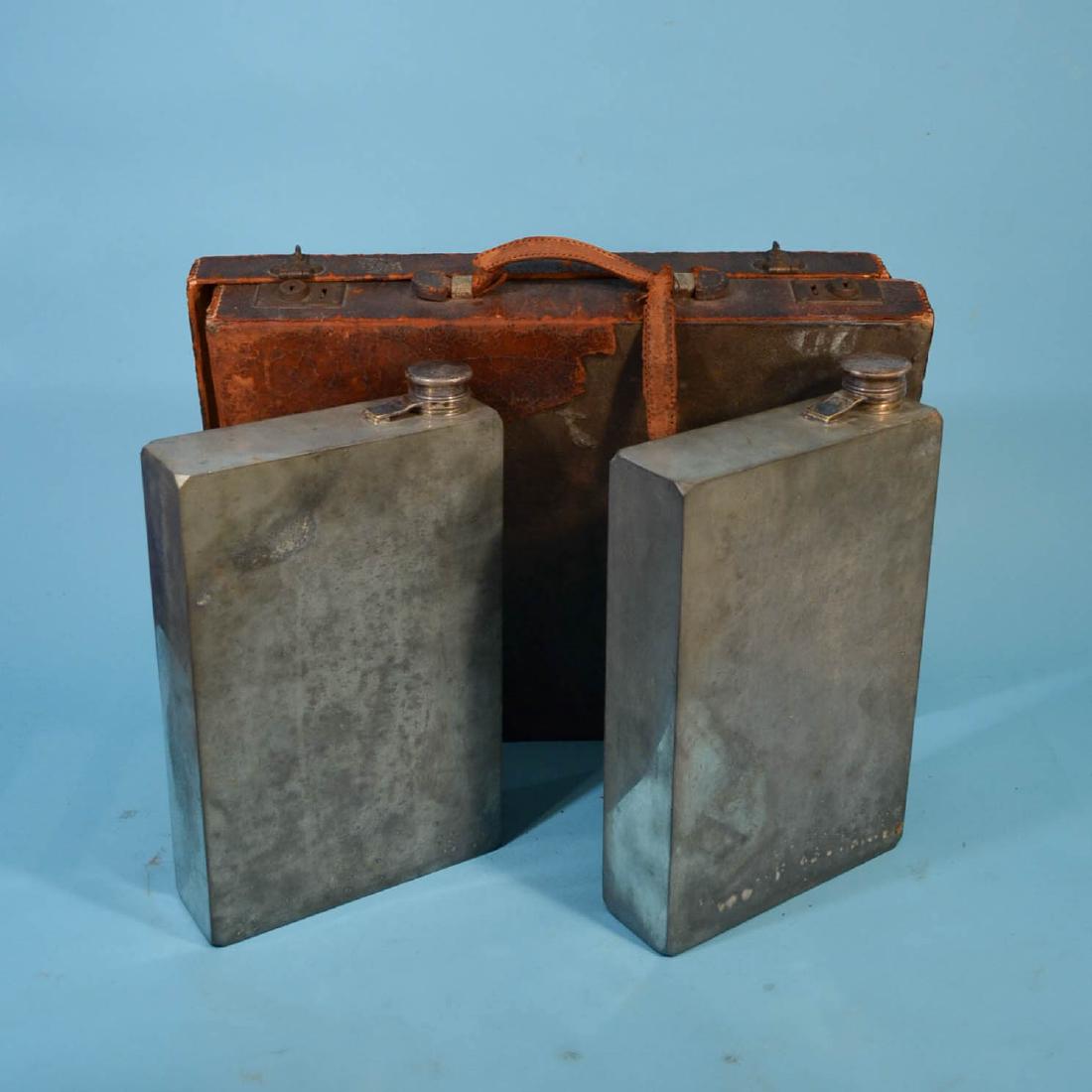 Meriden Abercrombie Prohibition Flasks in Briefcase: Meriden 128oz signed at base pewter cannisters x 2. They measure 13.25" x 8 x 2.5. In original case, which has deterioration, damaged hinges.