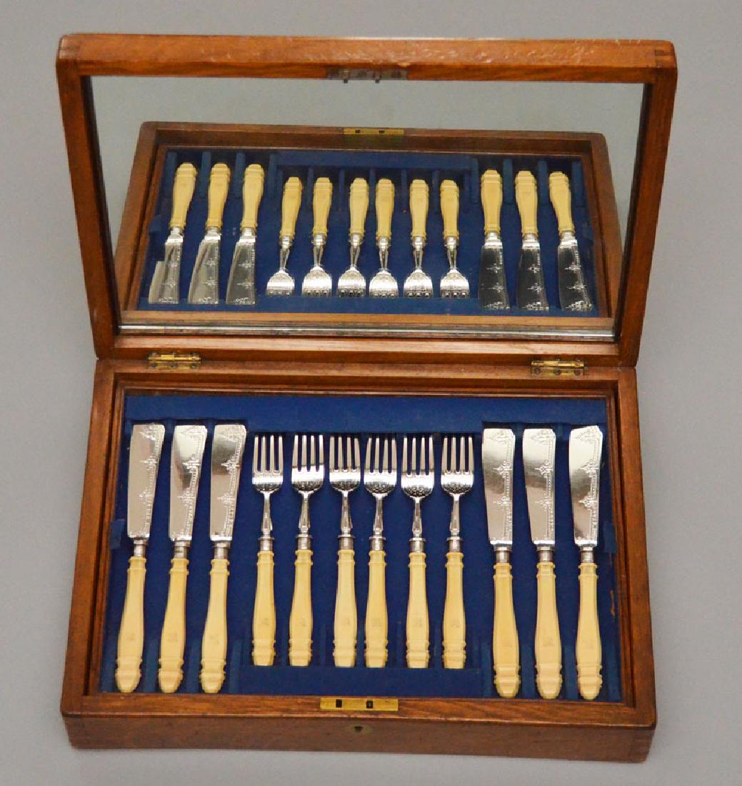 BEAUTIFULLY BOXED Sterling & Bone Fish Set: Frederick Elkington Sterling with bovine bone handles engraved with an elephant head. Includes 6 knives (9 1/8"), 6 forks (7 7/8"), a serving fork (10") and knife (12.75"). Box measures 3 7/8" tall x