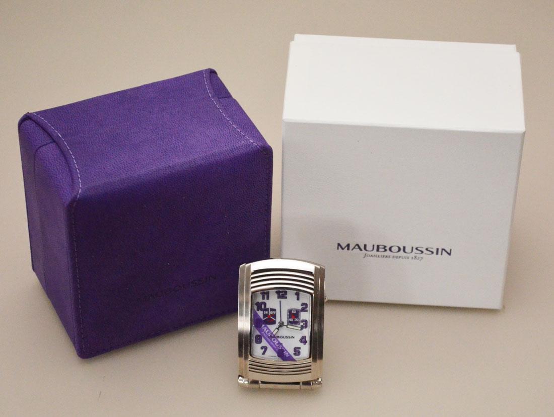 Mauboussin Fouga Travel Alarm Clock: The case is made from a solid stainless steel and folds over to protect the dial. The crown is hidden on the right side of the case and has a button next to it. The closed case measures 40mm wide x 65