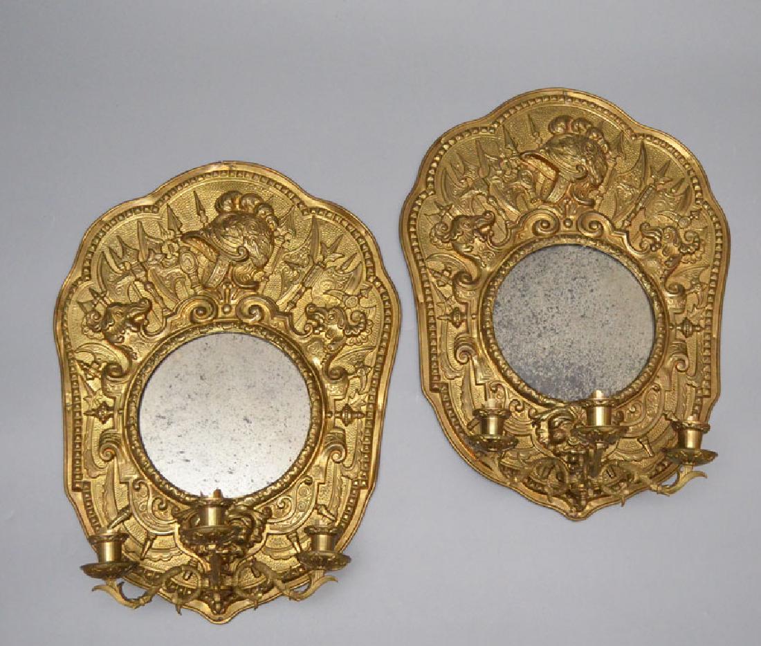 Pair Of Antique Brass Repousse Mirrored Sconces: Knight, Medieval style mirrored wall sconces. They measure 21.75" tall x 16.25" wide x 7.5" deep