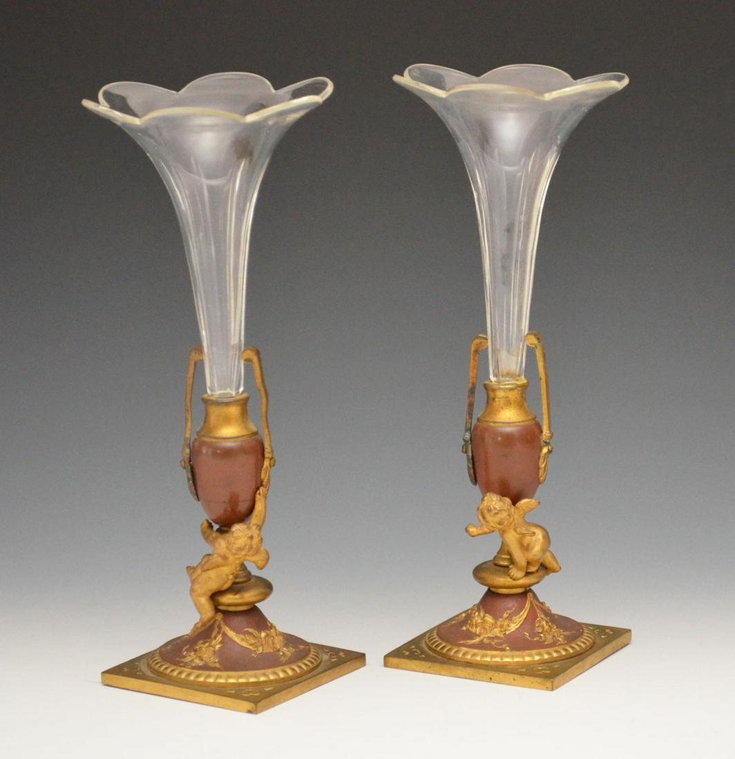 Pr Of Small Bronze Cherub & Glass Bud Vases: They measure 8" tall. Very nice overall condition, one has a repaired handle, one has removable vase, the other is glued in.