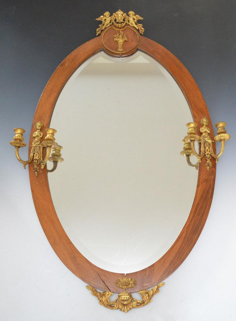 Large Beveled Mirror With Ormolu: Measures 45.5" tall x 28.5" wide at widest points, there are a few spots of wear on silvering on mirror, crack and split at joint at bottom. Split at joint at top, still a beautiful piece!