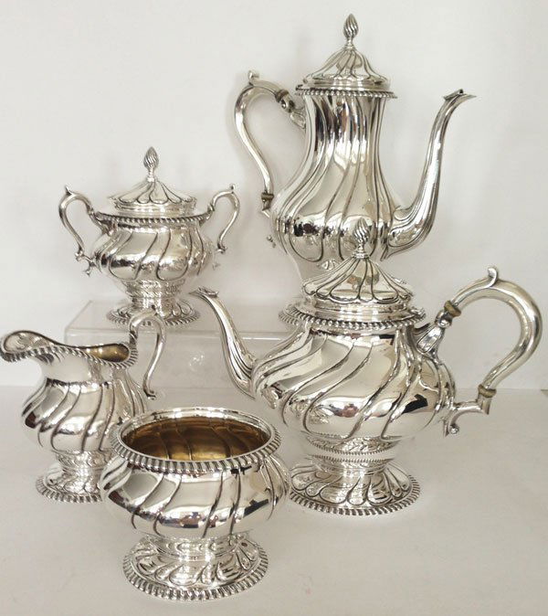 Hand Fluted Edwardian Tuttle Sterling Silver Tea Set: 5 Pcs. The sugar dish measures 6 1/2 x 3 5/8 inches. The gross weight is approx. 19.80 OZT. The shorter broader teapot measures 6 1/8 x 4 3/4 inches. The gross weight is approx. 35.61 OZT. The bowl me