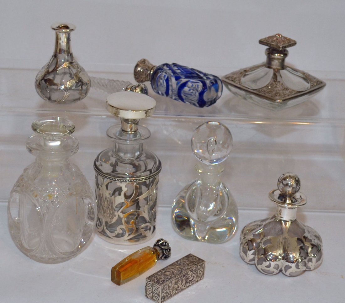 Collection Sterling Silver Perfume Bottles: Collection of 8 bottle and a lipstick case. Tallest bottle is Meriden Brittania sterling measuring 5.25" tall. Pressed glass bottle 5" tall. Short silverplate bottle 2.75" tall. Alvin silver overlay b