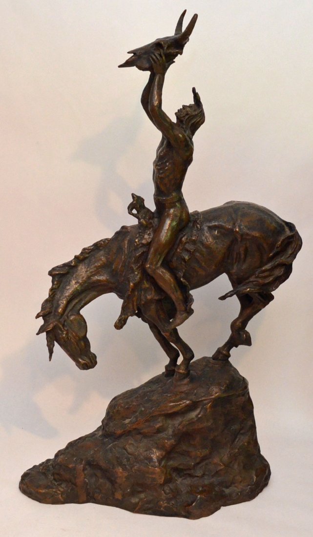 Monumental Charles M Russell American Indian on Horse: Native American horseback holding a bull skull in the air. Signed on the side. Measures 33.5" tall x 18" long x 9.25" wide at base