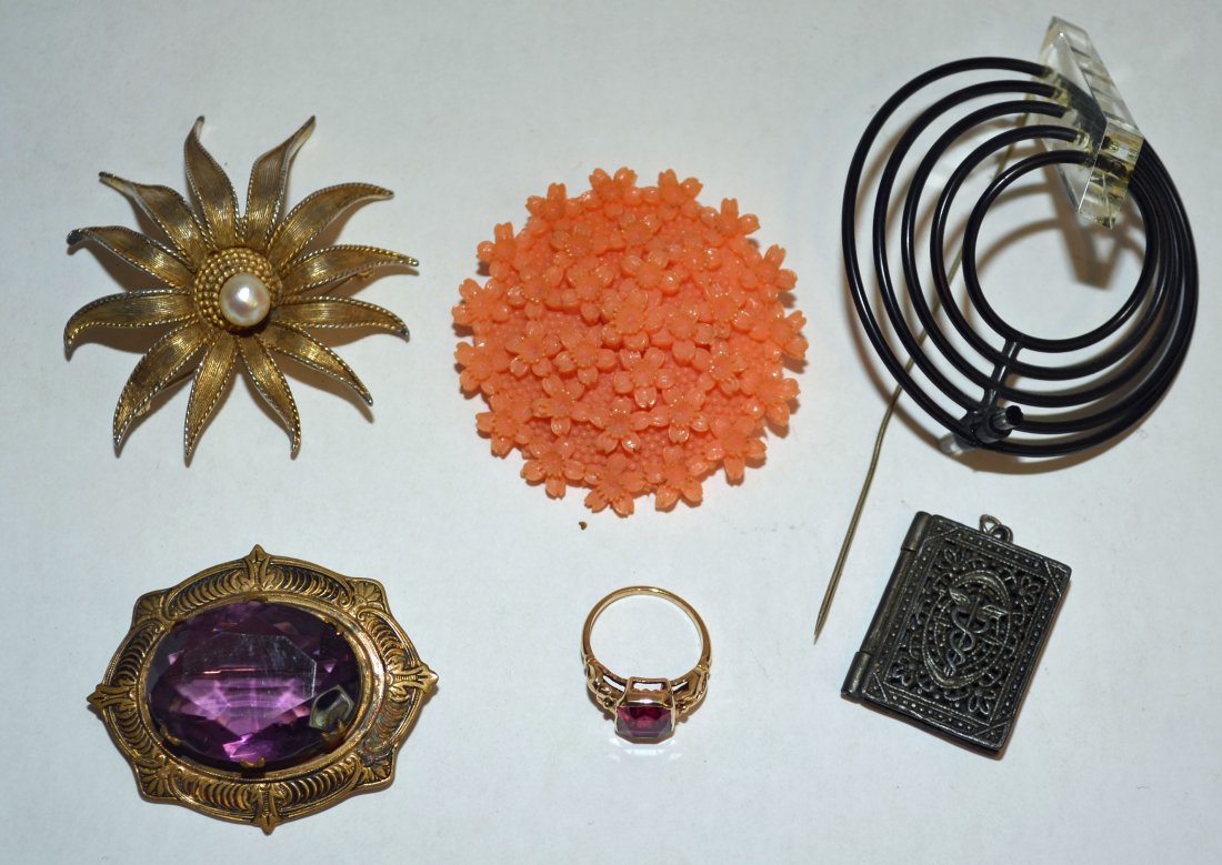 Fun Collection of Jewelry: Lot includes: a lucite spiral pin (3" diameter), Boucher gold tone/pearl brooch (2.25" diameter), medical sign locket pendant (1 1/8" x 7/8"), amethyst pin (2" x 1.5"), a faux coral pin (2" diameter) 