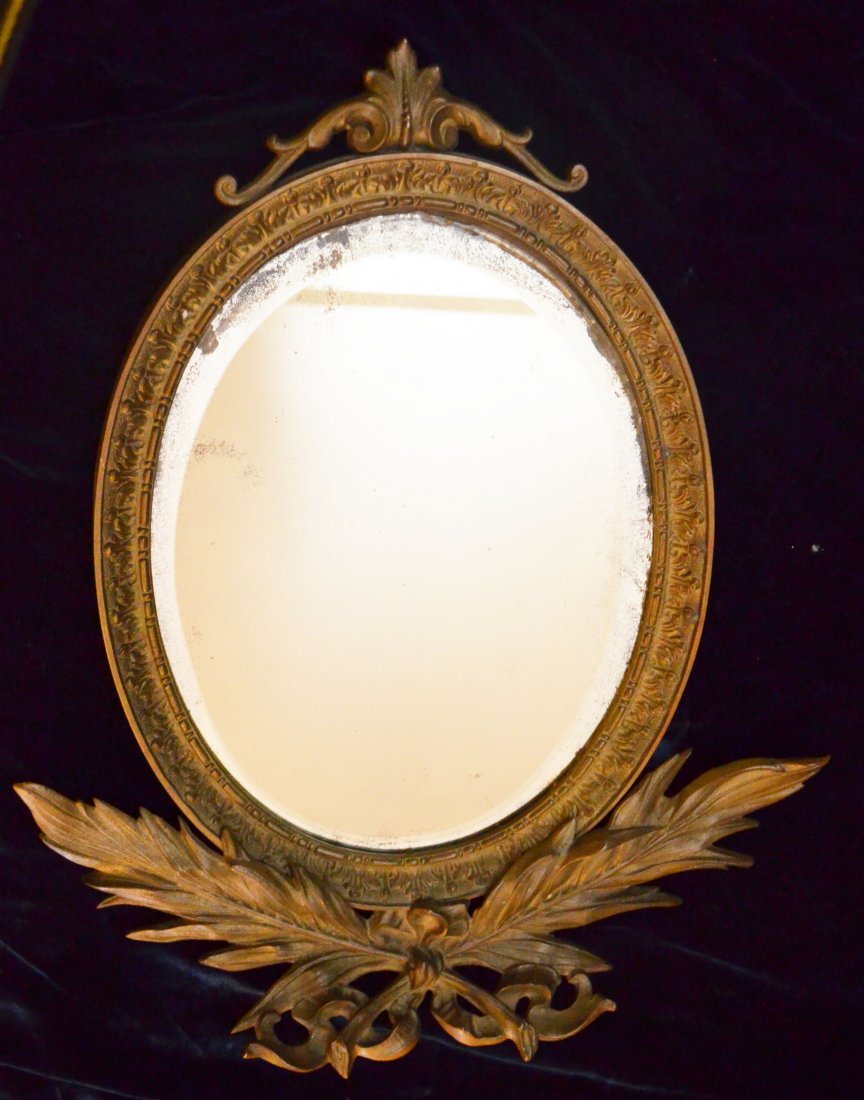 Stunning Neo Classical French Bronze Mirror: Oval bronze frame with original mirror. Measures 18.5" long x 15.75" wide at widest points.