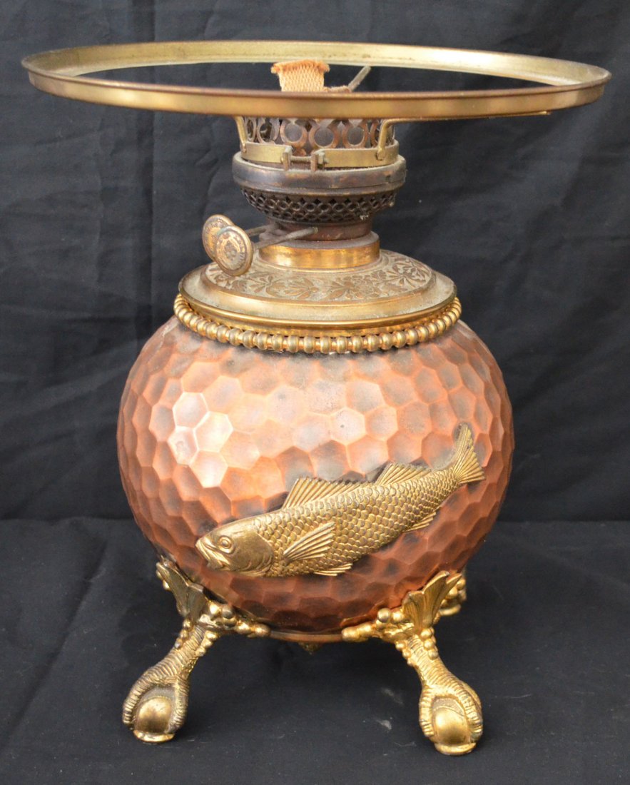 Copper Miller Arts & Crafts Adirondack Style Oil Lamp: Hand hammered style base with fish (perch or trout?), signed E. Miller & Co Duplex on the knobs. Measures 12" tall x 6.5" wide at base.