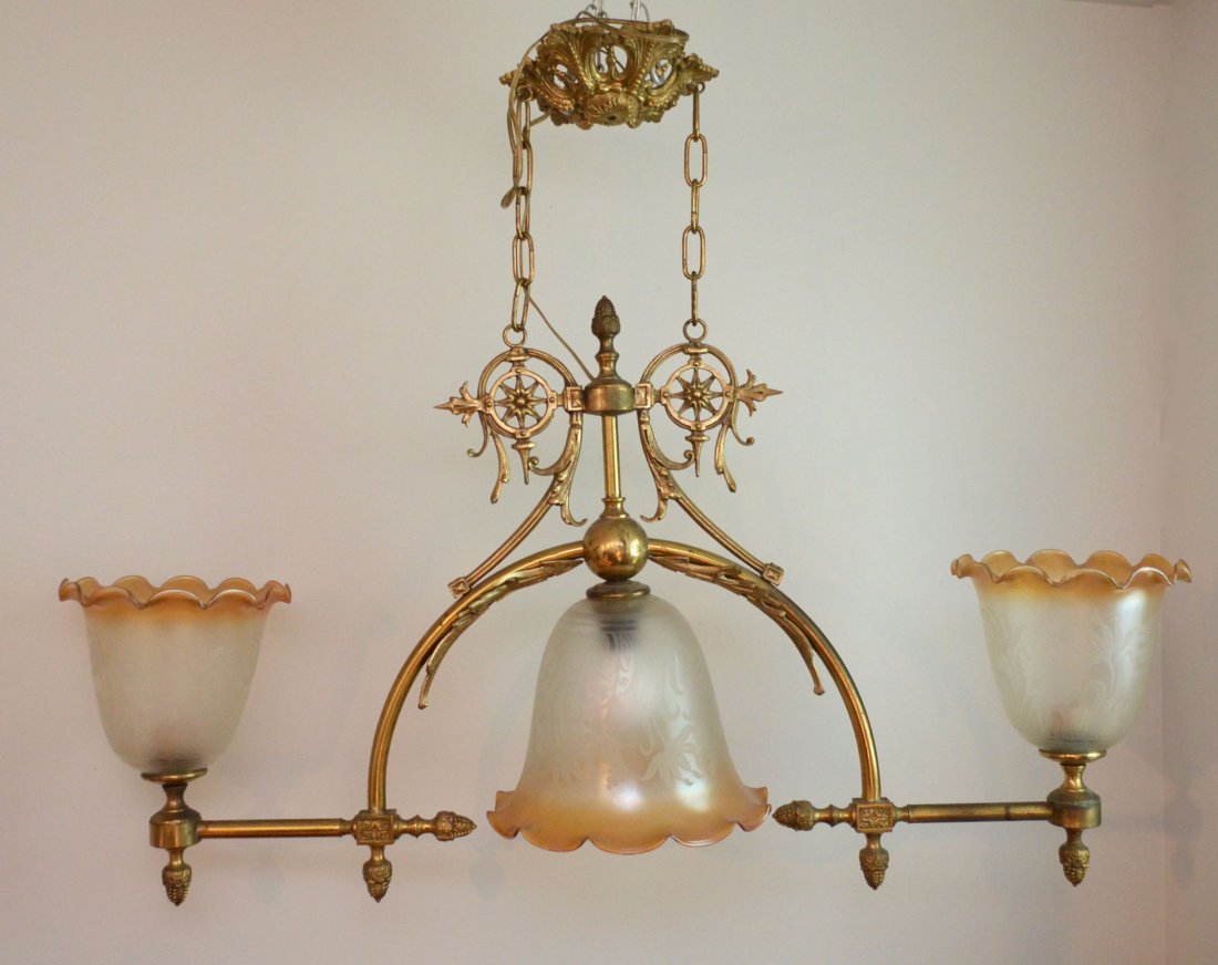 Brass Billiards Table Hanging Electrified Gas Light: Brass or brass colored billiards table light fixture, likely was originally gas, but has been electrified. Has 3 Glass globes. Measures 28" tall x 36" long from end of arm to end of arm. The largest