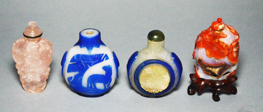 4 Carved Glass & Stone Snuff Bottles: Lot includes: 2 Peking glass lapis blue on whit background, carnelian with opaline background, and rose quartz. They range from 2.5" to 3.25" tall
