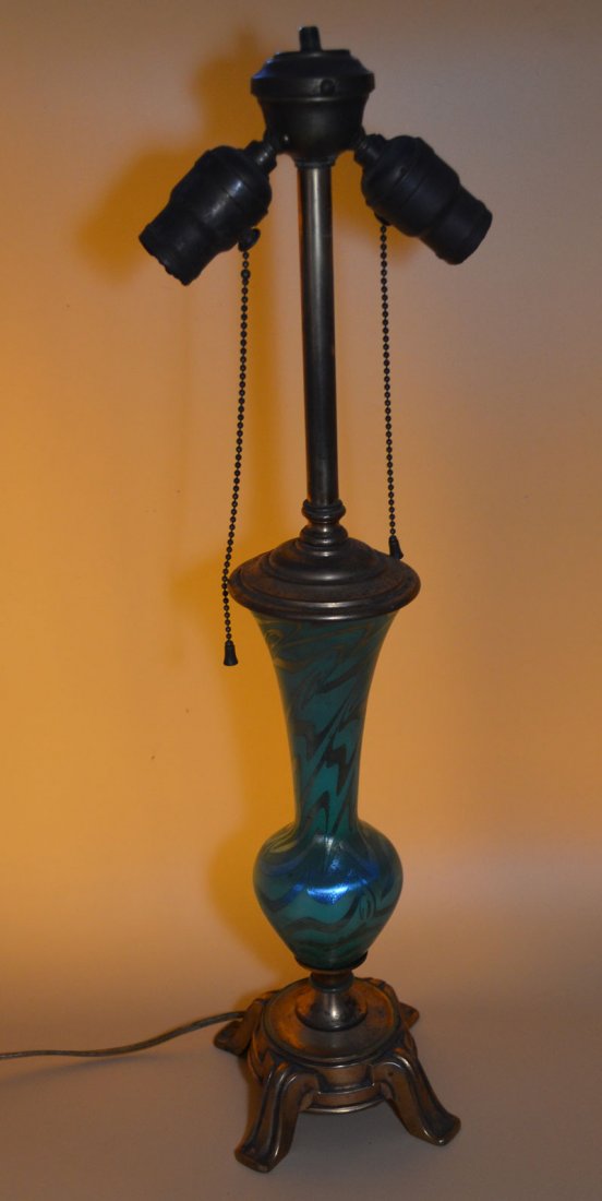 Durand Art Glass King Tut Table Lamp: Art glass and ormolu metal Vineland, New Jersey, early 20th century Vasiform lamp of lustrous gold pulled and hooked designs over blue-green, mounted on a four-footed gilt-metal base, crack in knob on