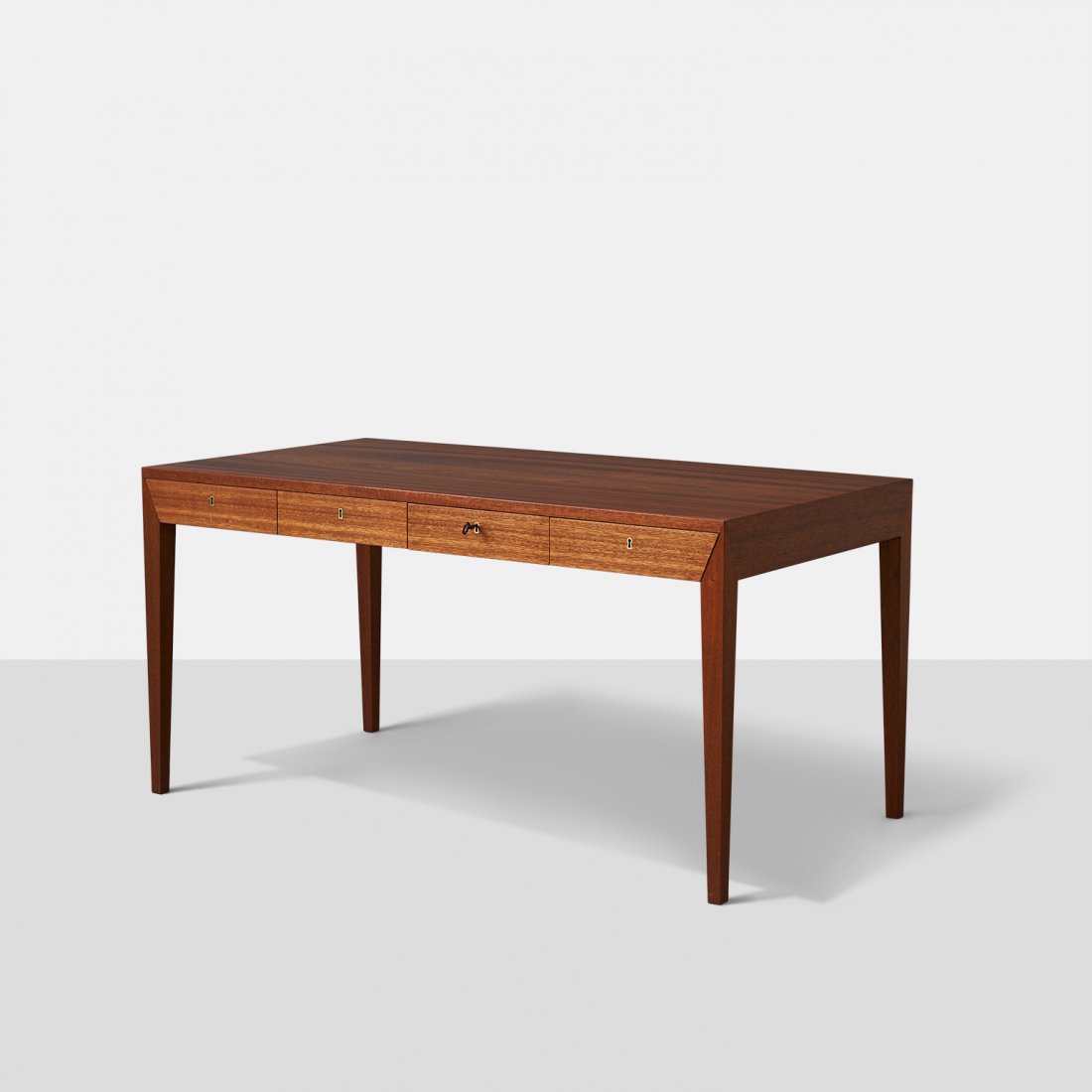 Severin Hansen Jr., Writing Desk for Haslev: A mahogany writing desk, by Severin Hansen Jr. The desk sits on stiletto legs and has four individually locking drawers, with brass edged keyway.Denmark, c1958Width : 56.25" Depth : 29.5" He