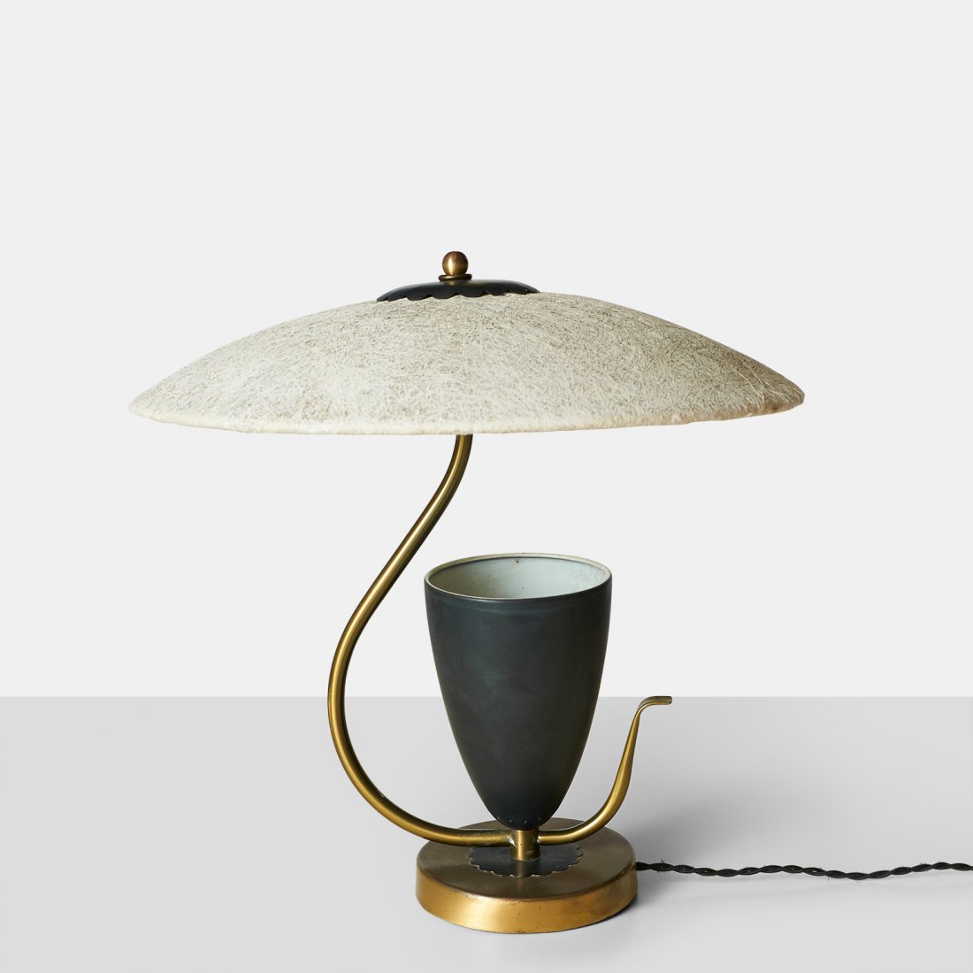 Table Lamp, In the Manner of Mitchell Bobrick: An elegant brass and black laquered steel table lamp with conical uplight base and a fiberglass shade. In the manner of Mitchell Bobrick.Italy, c1950sDiameter : 17.5" Height : 17"Brass, Pain