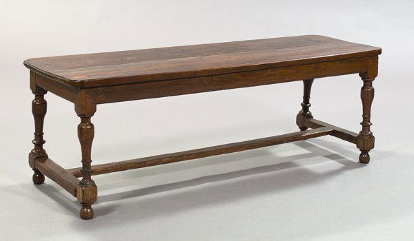 English Oak Bench- Table: English Oak Bench- Table, the long rounded, rectangular top raised on turned and bulbous legs joined by an "H"-form stretcher, ending in bun feet, h. 20", w. 58", d. 18".