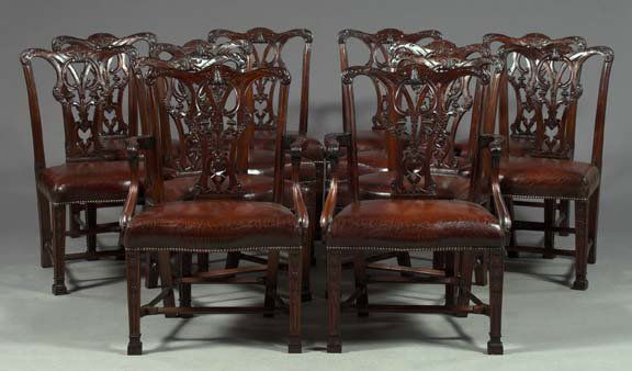 Suite of Twelve English Mahogany Dining Chairs: Suite of Twelve English Mahogany Dining Chairs, consisting of two armchairs and ten sidechairs,^ in the manner of Thomas Chippendale (1718-1779), the backs with a pierced baluster splat above a shaped