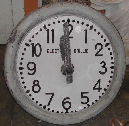 Electrique Brillie Copper and Lead Wall Clock: Large and Rare Circular Electrique Brillie Copper and Lead Wall Clock, the enameled tin dial with cut-tin hands, a white enamel ground and bas-relief chapters in black, with the "Electrique Brillie" l
