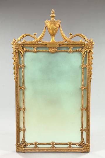 English Carved Giltwood and Composition Mirror: English Carved Giltwood and Composition Looking Glass, second quarter 20th century, in the manner of Robert Adam (English, 1728-1792), the cresting modeled as a covered draped antique vase in gilt com