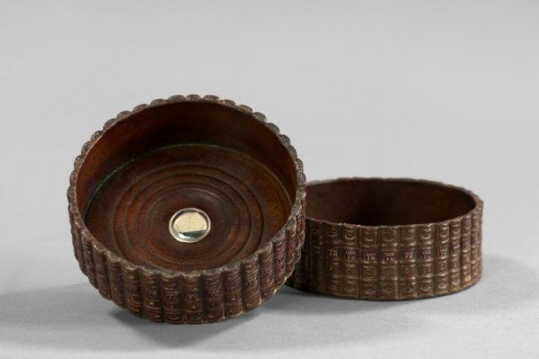 English Silver-Mounted Terra Cotta Wine Coasters: Pair of English Silver-Mounted Wood-Grained Terra Cotta Wine Coasters, in the form of a ring of leather-bound books, each cavetto centered with a silver box, h. 1-3/4", dia. 5".