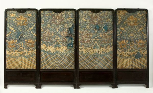 Kuang Hsu Carved Wood-Framed Folding Screen: Good Kuang Hsu Carved Wood-Framed Four-Panel Folding Screen, first quarter 20th century, the panels of two different widths, each panel filled with a period embroidered Chinese court robe on the facad