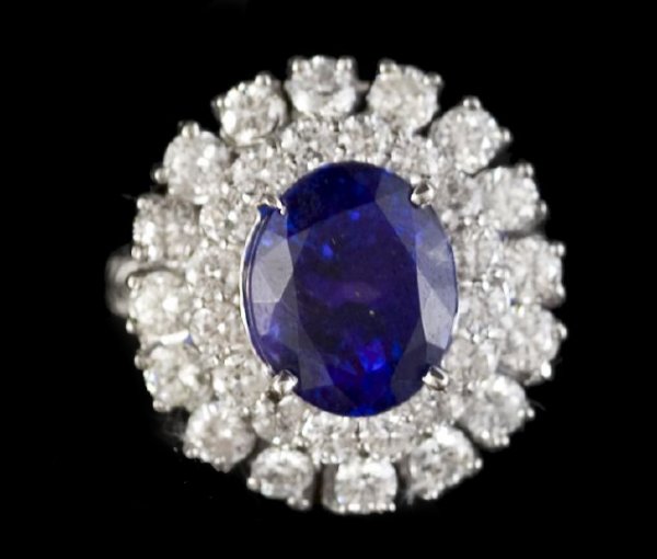 Gold, Tanzanite and Diamond Lady's Dinner Ring: Fourteen-Karat White Gold, Tanzanite and Diamond Lady's Dinner Ring, composed of a central oval-cut deep colored tanzanite weighing 5.14 carats surrounded by a double row of round brilliant-cut diamon
