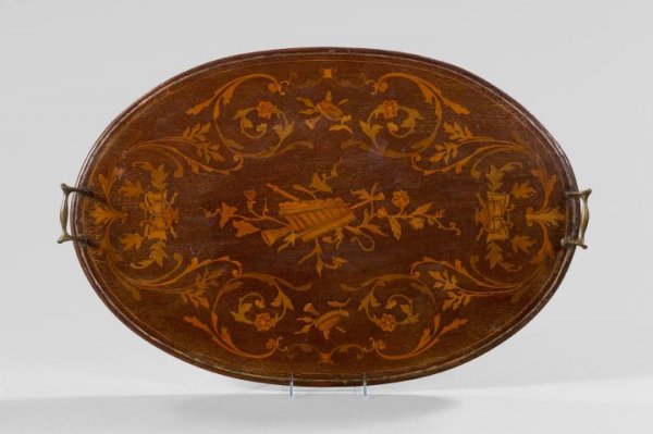 Edwardian Mahogany Marquetry Butler's Tray: Edwardian Brass-Mounted Mahogany and Holly Marquetry Butler's Tray, first quarter 20th century, of oval form in the Louis XVI taste, the center with a leaf-mantled inlaid musical trophee, the inlaid b