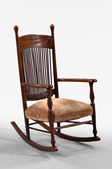 American Late Victorian Oak Rocking Chair,: American Late Victorian Oak Rocking Chair, ca. 1900, with an arched top rail over a spindle gallery, the turned stiles joined to open arms, the legs joined by boxed stretchers, h. 43", w. 24", d. 33".