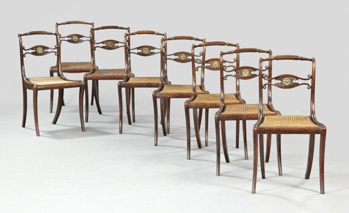 Suite of Eight Regency Faux-Bois Sidechairs,: Suite of Eight Regency Faux-Bois Sidechairs, first quarter 19th century, each with a slightly domed crest, above a shaped and foliate-carved splat centered by a brass medallion, the caned seat raised