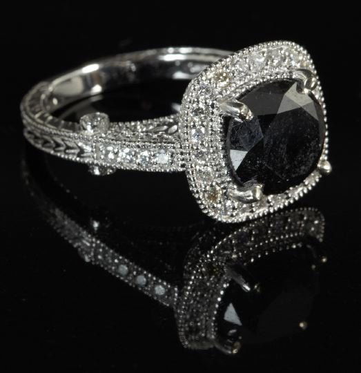 Gold and White and Black Diamond Lady's Ring: Fourteen-Karat White Gold and White and Black Diamond Lady's Ring, composed of a central round-cut black diamond weighing 4.79 carats in an Art Deco-style filigree mounting set with one hundred four r