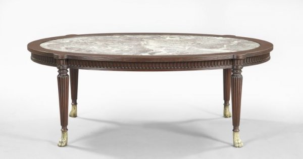 Mahogany and Marble-Top Coffee Table: Sheraton-Inspired Mahogany and Marble-Top Coffee Table, early 20th century, the oval top with an insert violet breccia marble top, raised on turned and reeded legs ending in brass paw feet, h. 17", w.