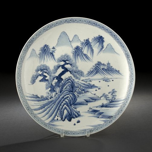 Japanese Blue and White Imari Porcelain Charger: Japanese Blue and White Imari Porcelain Charger, first half 20th century, decorated in underglaze blue depicting a South China landscape with craggy peaks, pavilions alongside a lake, and an ancient p