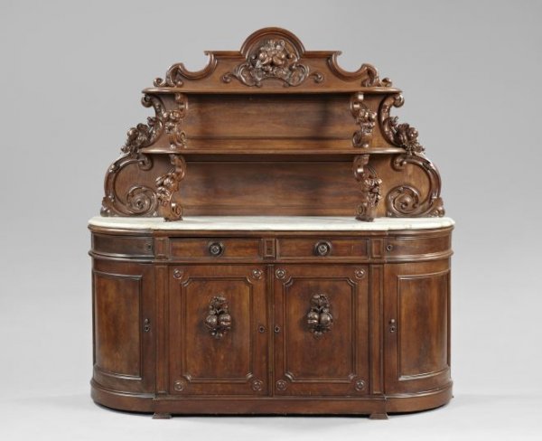 American Rococo Oak and Marble Sideboard: American Rococo Revival Oak and Marble-Top Sideboard, third quarter 19th century, attributed to Alexander Roux, New York, the top section with a pair of graduated shelves supported by large fruit-carv