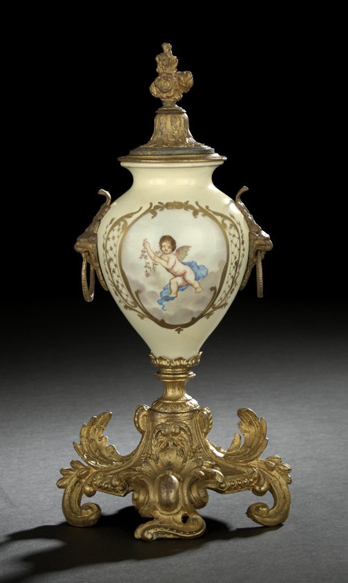 French Porcelain Two-Handled Garniture Vase: French Porcelain Covered Two-Handled Garniture Vase, fourth quarter 19th century, the gilt-spelter- and brass-mounted vase in the "Sevres" manner, the handles modeled as ringed lion masques, the gilde