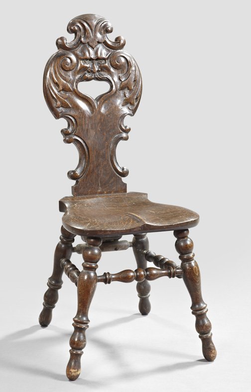 Continental Carved Oak Hall Chair,: Continental Carved Oak Hall Chair, fourth quarter 19th century, in the Renaissance taste, the relief-carved back with a central face and open mouth, the saddle-shaped seat mounted to turned legs, h. 4