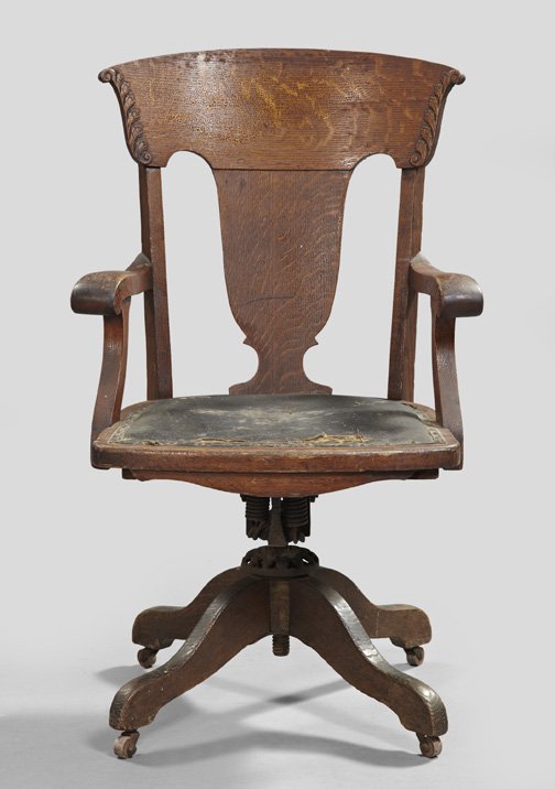 American Oak and Quarter-Sawn Oak Office Chair: American Oak and Quarter-Sawn Oak Office Chair, ca. 1900, the cast-iron hardware with the molded label of the Milwaukee Chain Company, the back with concave top rail, shaped splat and open arms, the s