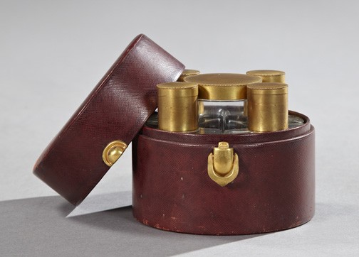 Good French Leather Gentlemen's Cologne Case,: Good French Leather Gentlemen's Cologne Case, second quarter 20th century, of circular form and fitted with four shaped cologne bottles enframing a central glass talc jar, all of the glass vessels wit