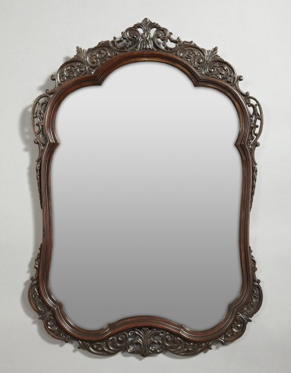 Edwardian Jigsawn Mahogany Mirrors: Pair of Edwardian Carved and Jigsawn Mahogany Looking Glasses, first quarter 20th century, of scalloped-top cartouche form in the rococo taste, the cresting modeled as a tangent trio of addorsed folia