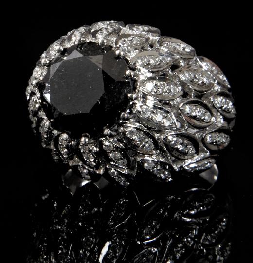 Gold and Black and White Diamond Ring: Dramatic Fourteen Karat White Gold and Black and White Diamond Ring, featuring a prong-set round fancy brilliant-cut black diamond, set within a bouquet of cascading white diamond-set leaves, total we