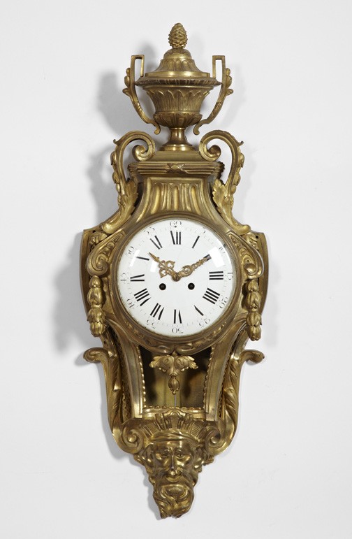 Belle Epoque Cast Gilt-Brass Wall Clock,: Belle Epoque Cast Gilt-Brass Wall Clock, first quarter 20th century, in the Louis XVI style, the cresting modeled as an antique covered two-handled vase, the basal finial modeled as a diademed river g