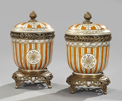 Porcelain Covered Garniture Vases-on-Stand: Pair of Continental Porcelain Covered Garniture Vases-on-Stands, with reticulated brass mountings in the Louis XVI style, the vases of deep bowl form and painted in parcel-gilt orange stripes alternat