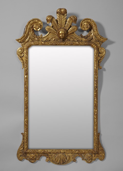 English Elaborately Carved Giltwood Mirrors: Large Pair of English Elaborately Carved Giltwood Looking Glasses, in the style of William Kent (1684-1748), each broken-scroll pediment centered with a large giltwood putto masque backed by "Prince o
