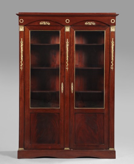 Empire-Style Mahogany Cabinet,: Empire-Style Mahogany Cabinet, 20th century, the molded cornice above a case fitted with two doors, each with an upper glazed section and a lower paneled section, flanked to either side by engaged orm