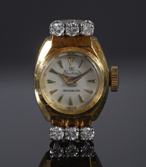 Gold and Diamond Nadine Ring Watch: Eighteen-Karat Yellow Gold and Diamond Nadine Ring Watch, in the form of a lady's ring with a white enamel-faced watch accented at each end with three round brilliant-cut white diamonds, size 6-1/2.